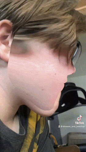 a close up of a person 's face with tik tok written on the bottom right corner
