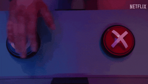 a person is pressing a red button with an x in it