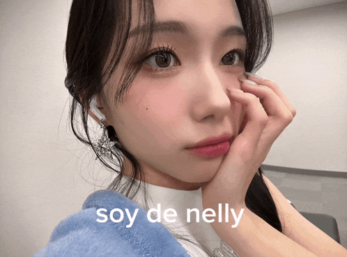 a close up of a woman 's face with the words soy de nelly written above her
