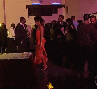 a woman in a red dress is dancing in a crowd of people