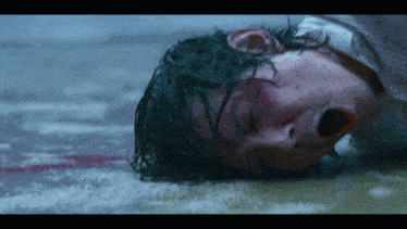 a man with green hair is laying on the ground with his mouth open