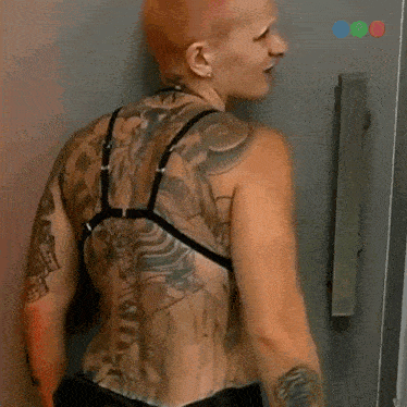 a woman with red hair and tattoos is wearing a bikini top