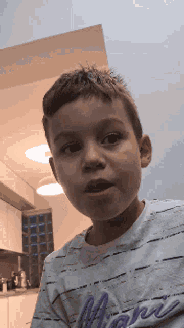 a young boy wearing a shirt that says miami