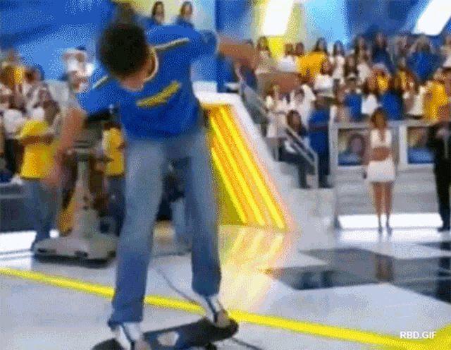 a man in a blue shirt is riding a skateboard