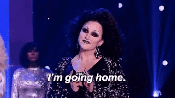 a drag queen says i 'm going home while holding a microphone