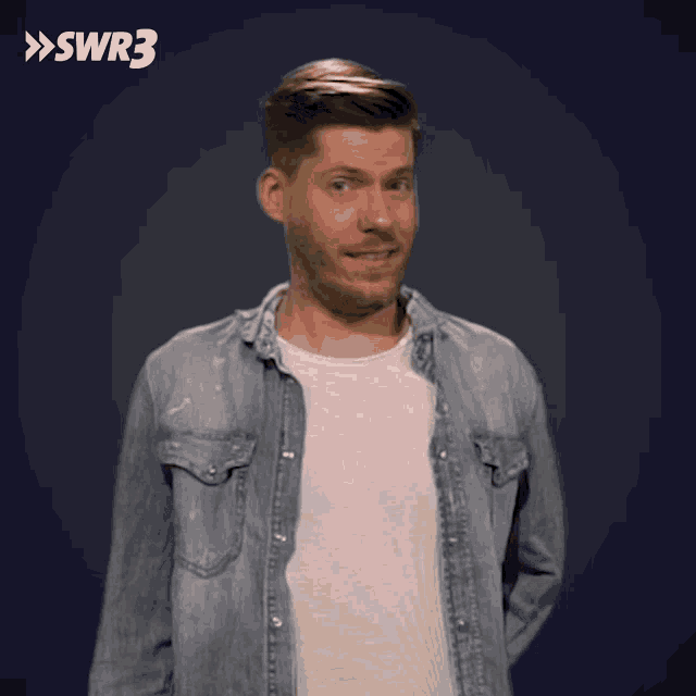 a man in a denim shirt is standing in front of a blue background with the letters swr3 on it