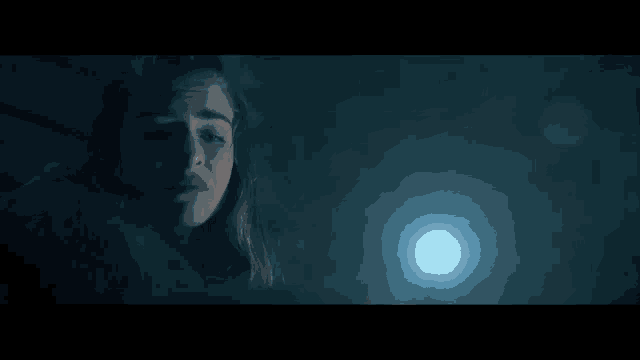 a close up of a woman 's face in a dark room with the words editing & vfx on the bottom .