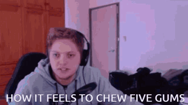 a young man wearing headphones is sitting in front of a microphone and says how it feels to chew five gums