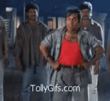 a man in a red tank top is dancing with a group of men