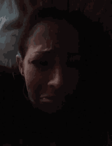 a close up of a woman 's face in a dark room