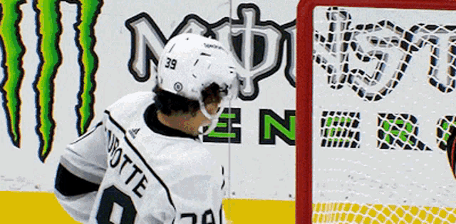 a hockey player with the number 39 on his helmet is standing in front of a monster energy sign