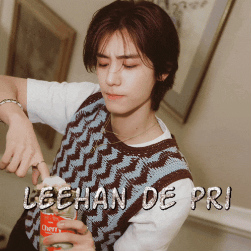 a man is holding a bottle of cherry soda in his hand