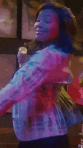 a woman is dancing in front of a microphone in a club