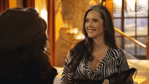 a woman in a zebra print dress is talking to another woman .