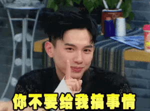 a young man is making a funny face with his finger on his lips and chinese writing behind him .