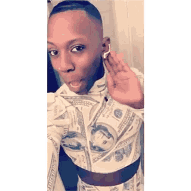 a man is wearing a crop top with money on it .