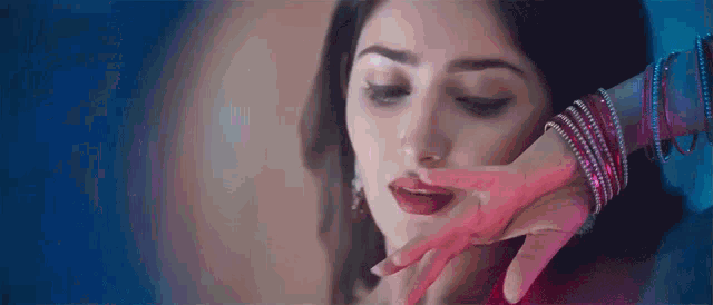 a close up of a woman 's face with a hand on it .