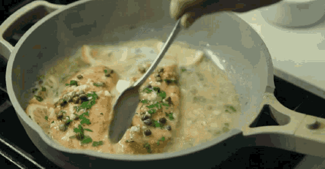 a spoon is being used to stir a pan of food