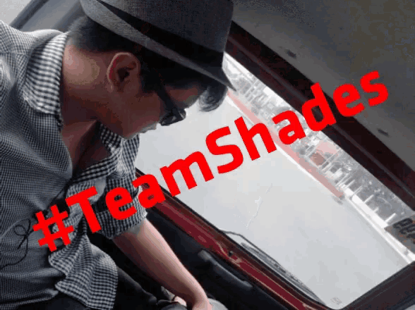 a man wearing a hat and sunglasses is sitting in a car with #teamshades written on the window