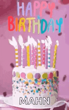 a birthday cake with candles and sprinkles on it and the words `` happy birthday mahn '' written on it .