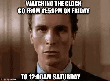 a man is watching the clock go from 11:59 pm on friday to 12:00 am saturday .