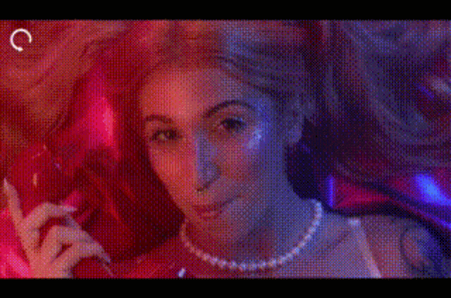 a woman is taking a selfie in front of a mirror in a bedroom with purple lights .