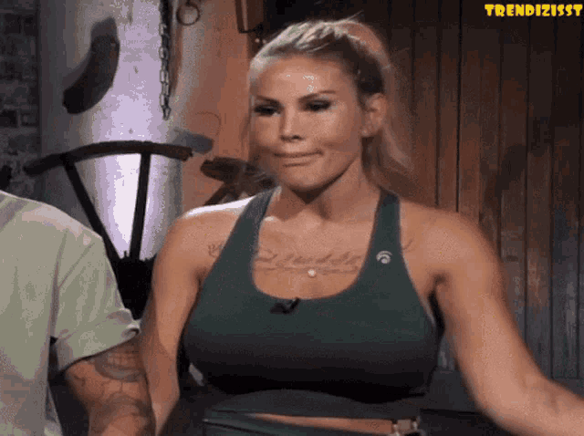 a woman in a green sports bra is standing next to a man in a green shirt with the word trendizissy on the bottom