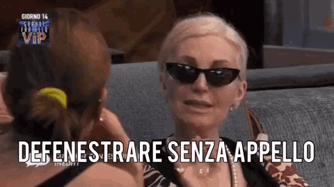 a woman wearing sunglasses is talking to another woman