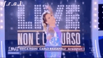 a woman is dancing on a stage in front of a sign that says non e l urso