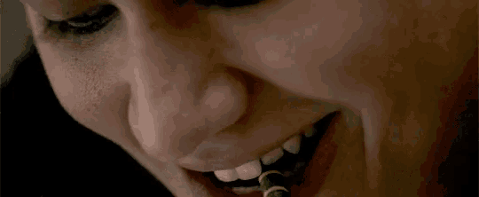 a close up of a woman 's mouth with a green pencil in it
