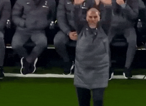a man standing on a soccer field with his hands outstretched