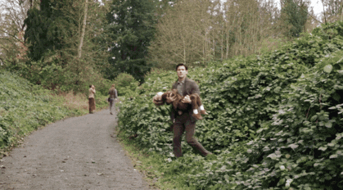 a man in a suit is carrying a dog on his back