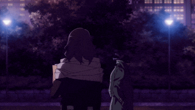 a man with a bag around his neck is standing in front of a street light at night