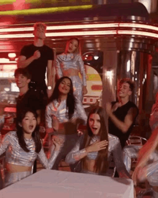 a group of people are standing around a table in a diner .