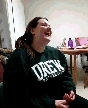 a woman wearing a drew university sweatshirt laughs
