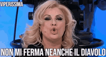 a woman is blowing a kiss in front of a camera with a caption that says viperissima non mi ferma neanche il diavolo