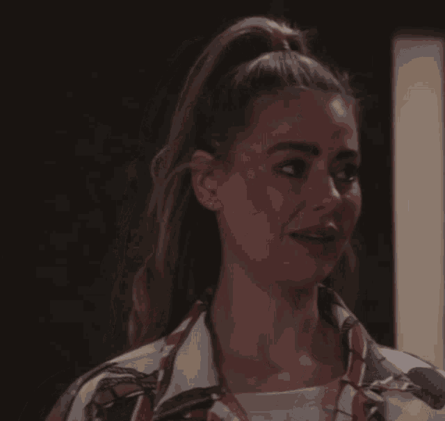 a woman with her hair in a ponytail is making a funny face
