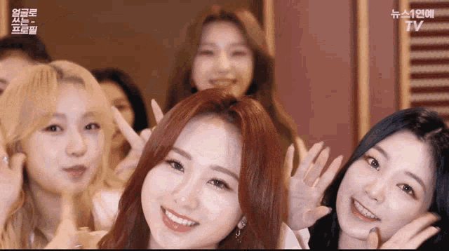 a group of young women are posing for a picture and one of them has a tv logo on her face