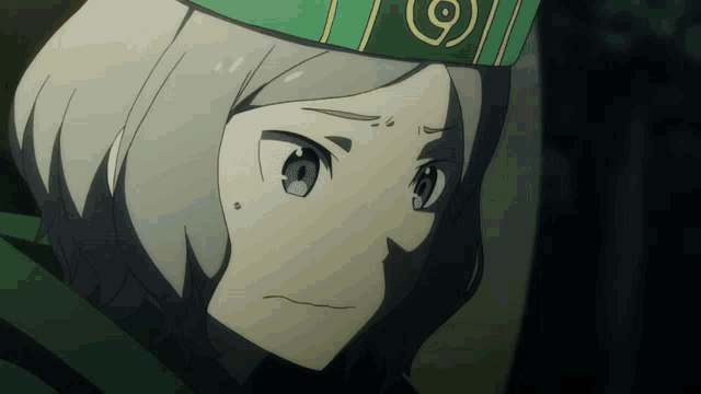 a close up of a person wearing a green hat