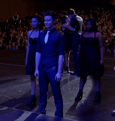 a group of people standing on a stage in front of a large crowd