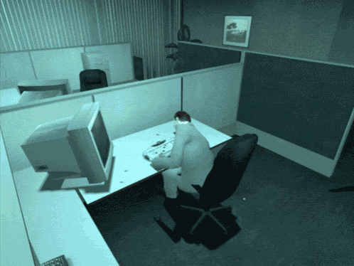 a man sits at a desk in front of a computer screen