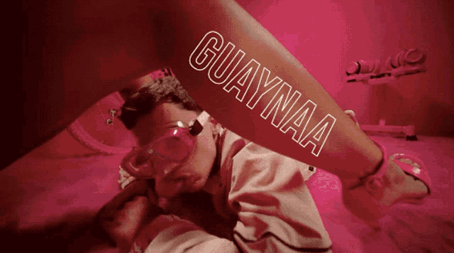 a man laying on the floor with a woman 's leg with the word guaaynaa written on it