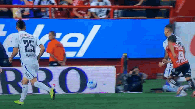 a soccer player with the number 25 on his jersey kicks the ball