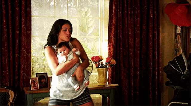 a woman is holding a baby in her arms in a room