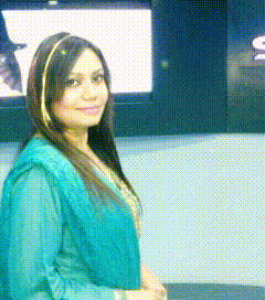 a woman in a blue dress stands in front of a tv