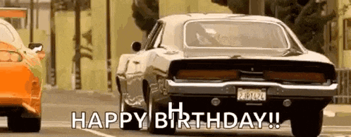a car is driving down a street with the words `` happy birthday '' written on the bottom .