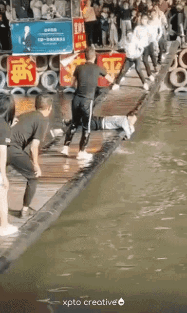 a group of people are standing around a body of water with a sign that says xpto creative on the bottom