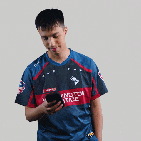 a man wearing a washington justice jersey looks at his cell phone
