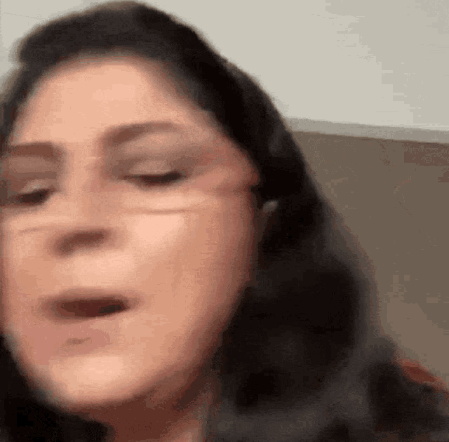 a woman 's face is shown in a blurry photo with her mouth open