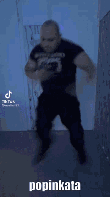 a man in a black shirt is jumping in the air with the words popinkata written on the bottom